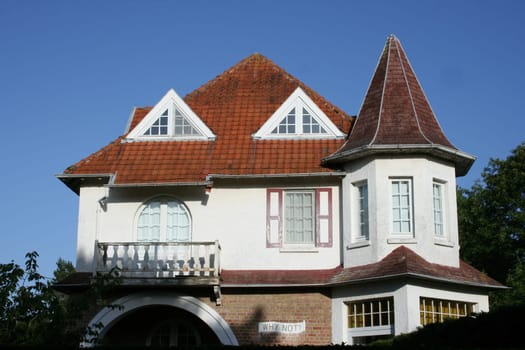 old house with balcony,bay window,and lattice windows