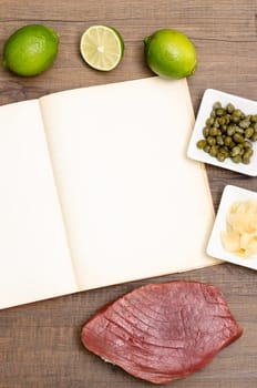 Paper with text space and tuna with ingredients on a table