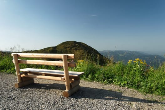 View over the mountains with a bench in the foreground