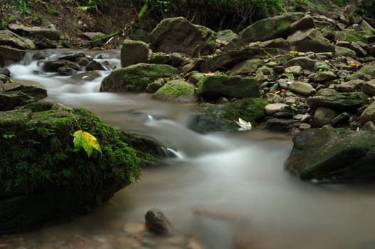Autumnal mood on a river with many stones