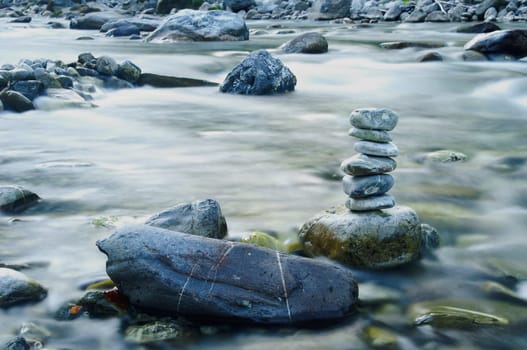 A stone man in the river on a stone