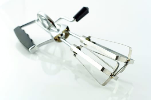Old hand mixer made of metal with white background