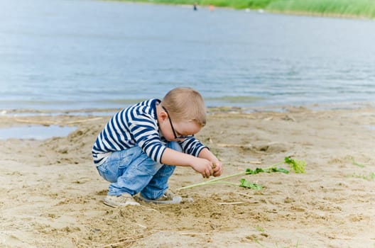 Boy and girl playing in the sand on the shore of Lake