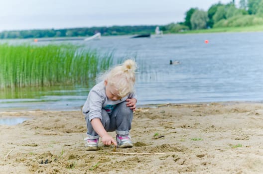 Boy and girl playing in the sand on the shore of Lake