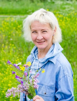 Portrait of a middle-aged woman with a bouquet of wild flowers