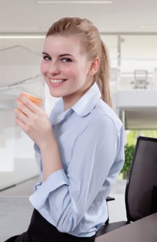 Successful business woman looking in the camera with a cup of coffee in her hand. Copy space.