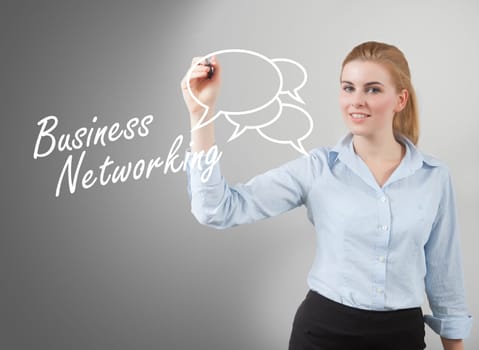 businesswoman hand writing 'business networking', grey background