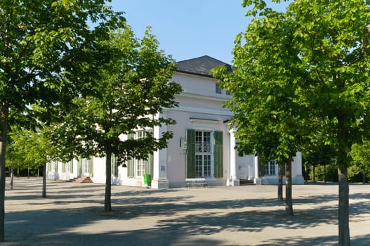 The Ballhaus is located directly north of Wilhelmshöhe Palace. King Jérôme of Westphalia,the youngest brother of Napoleon,had it built from 1809 to 1810 as a court theatre by Leo von Klenze. The freestanding,classicist building was placed next to the north wing of the castle and is an early work of the later famous architect. Between 1828 and 1830 it was converted into a ballroom by Johann Conrad Bromeis under Elector Wilhelm II of Hesse-Cassel. It was used less by the farm itself than by the hotel opposite.