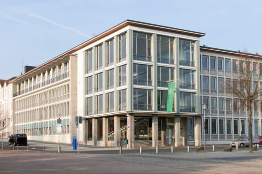 The AOK building at the southern corner of Friedrichsplatz zur Schönen Aussicht stands for the typical 50s architecture. The staircase is a particularly successful example with its transparency - created by large window surfaces embedded in fine reinforced concrete construction - which continues inside through the open curved staircase. In the stairwell is the sound installation "Three to One"" by Max Neuhaus – A documenta artwork from documenta 9 1992."