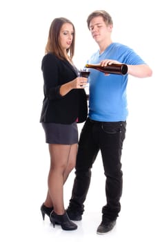 A young man and a young woman stand next to each other,she holds a glass of wine and he holds a wine bottle in his hand. Cropped against a white background.