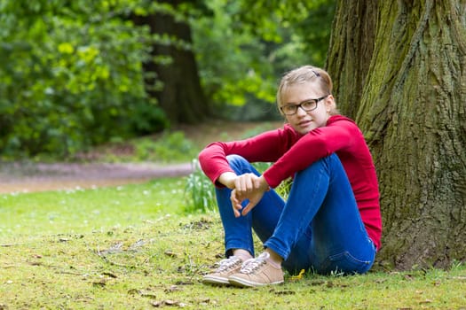 Young girl resting in park in spring day