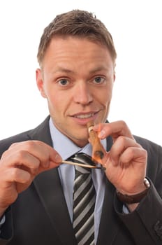 Young businessman in suit and tie sits at his desk and enjoys a good cigar from his humidor. Cropped against white background