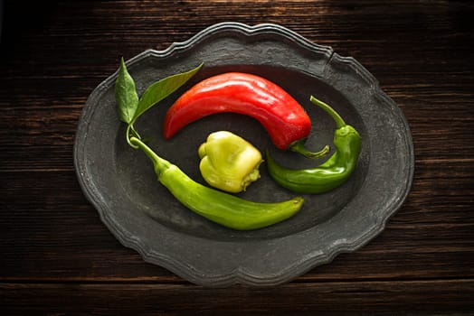 Fresh peppers on rustic plate close up shoot
