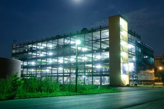 Modern multi-storey parking garage illuminated at night.