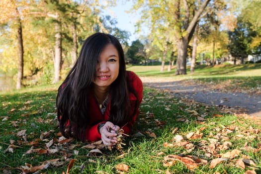Woman laying on grass looking happy