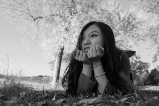 Woman laying on grass looking happy
