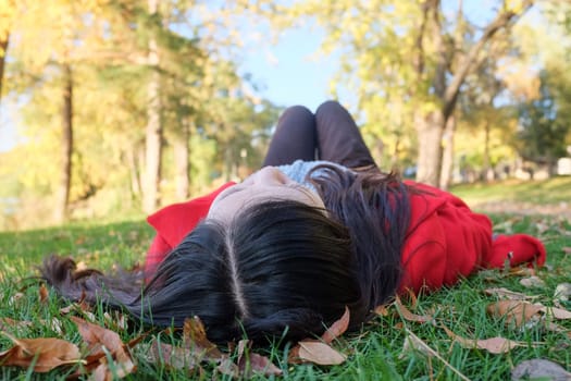 Young woman laying on grass looking at the sky