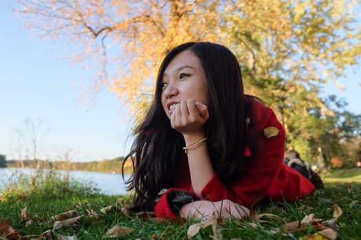 Woman laying on grass looking happy