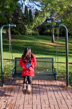 Young woman sitting on a swing chair