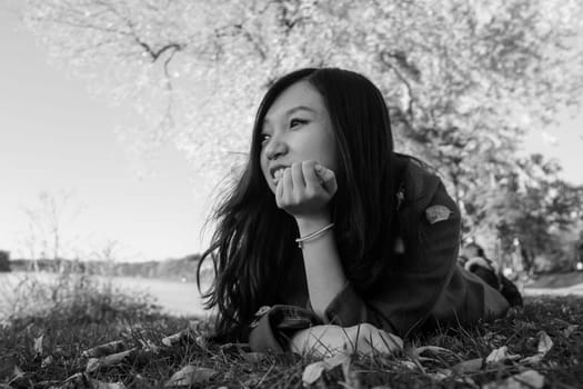 Woman laying on grass looking happy
