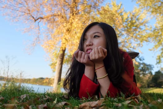 Woman laying on grass looking happy