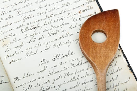 Old cooking spoon with cookbook
