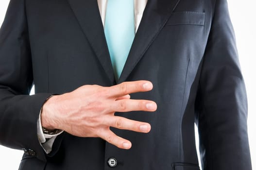 Chest-and-belly view of a young man in a black suit with his right hand held in front of him indicating the "4"" (four fingers)"