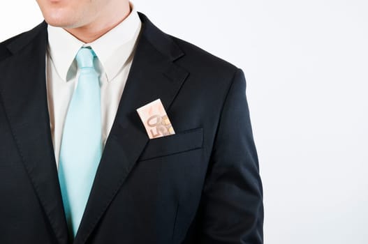 Upper body view without head of a young man in a black suit against white background with folded dollar bill outstanding from the outer chest pocket.