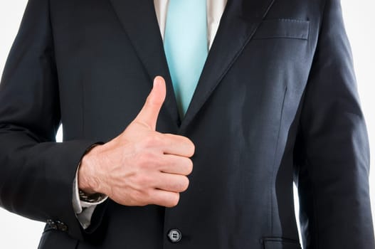 Chest-and-belly view of a young man in a black suit with his right hand held in front of him and indicating the "1"" (thumbs up)"