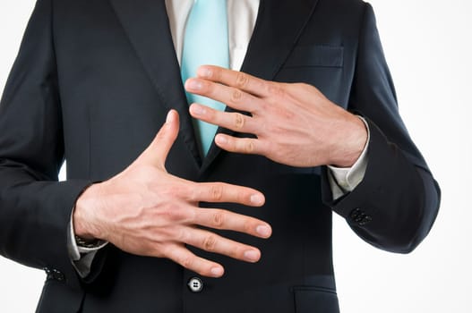Chest-and-belly view of a young man in a black suit with his hands held in front of him indicating the "9"" (nine fingers)"