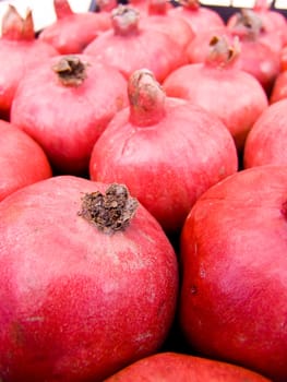 A pile of beautiful  pomegranates on a counter