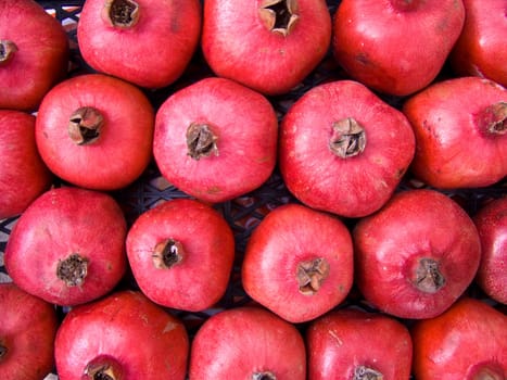 A pile of beautiful  pomegranates on a counter