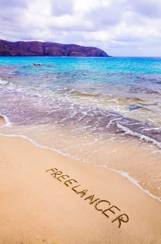 Word FREELANCER written in sand, on a beautiful beach, Freelance concept