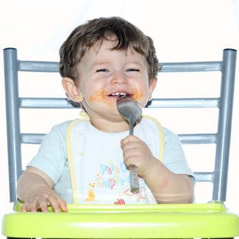Details of a young boy sitting on a chair and playing with a spoon.