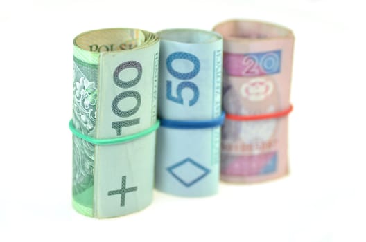rolls of polish banknotes and coins isolated on white