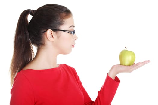 Young woman holding green fresh apple in hand, isolated over white background