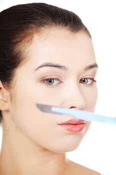 Cosmetic surgery concept. Female face in background of scalpel.