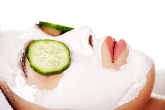 Young woman with cucumber slices on the face in a spa saloon