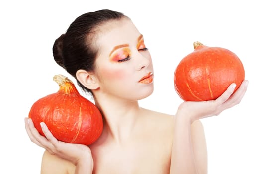 Beautiful woman with orange make up holding pumpkin
