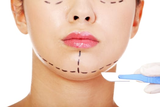 Cosmetic surgery concept. Female face in background of scalpel.