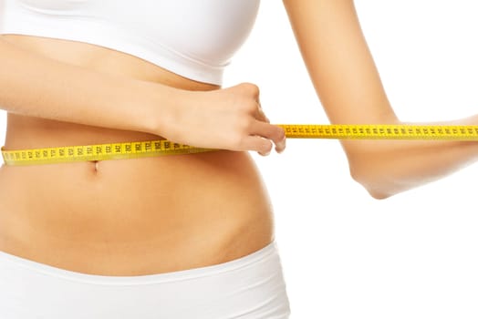 Slim fit woman in white panties with measure tape on white background
