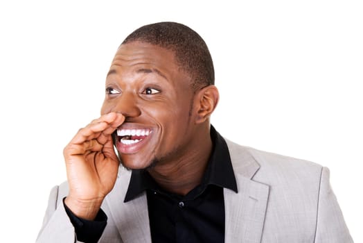male businessman smiling. he has his hand on mouth. isolated on white.