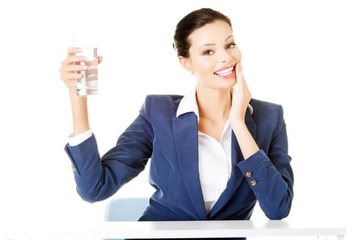 attractive business woman sitting holding a glass. isolated on white.