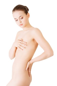 attractive young naked woman holding her breasts. back view. isolated on white.