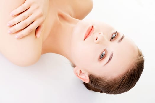 attractive woman lying on the floor and looking at camera. isolated on white.