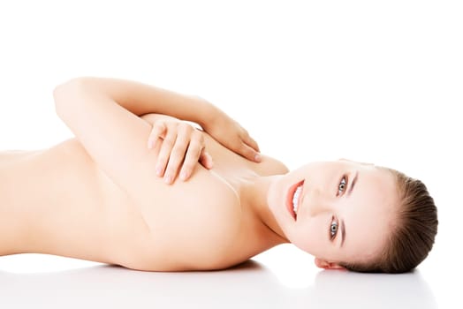 attractive naked woman lying on the floor looking at camera. isolated on white.
