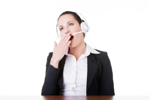 business woman with headphones yawning. isolated on white.