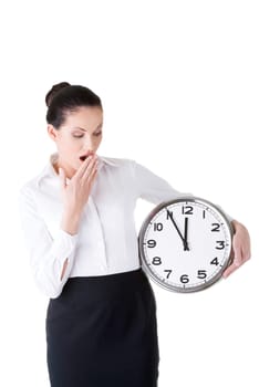 business woman holding a clock and yeaning. isolated on white.