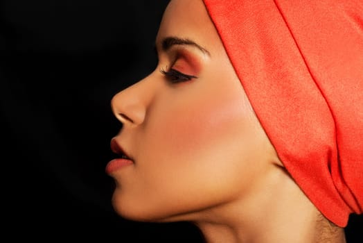 attractive woman's profile in a turban. closed eyes. isolated on black.