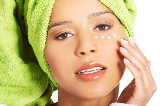 beautiful woman's face with cream under the eye. isolated on white.
